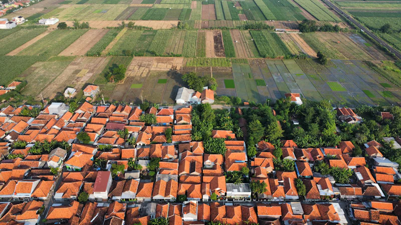 Pemandangan udara permukiman desa beratap merah di tengah sawah