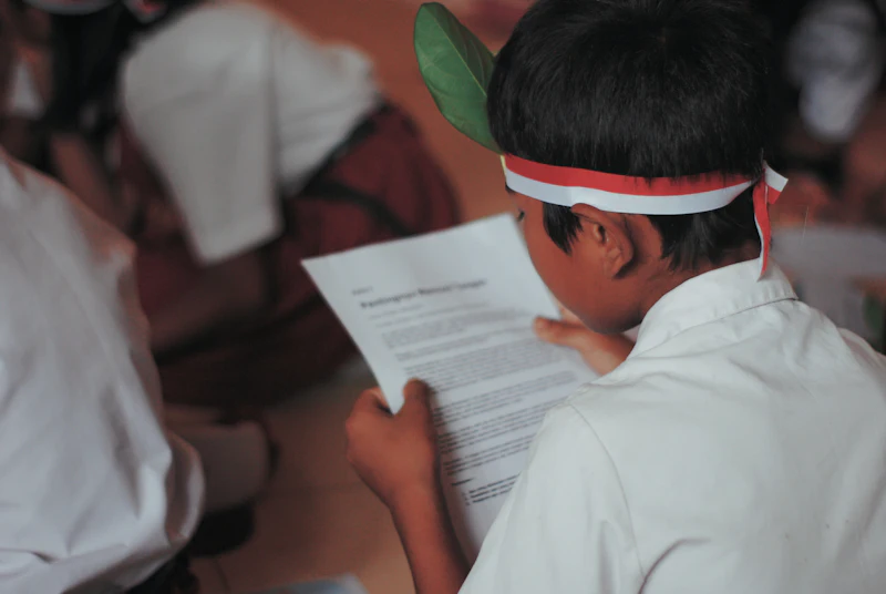 Pelajar berseragam membaca selembar dokumen