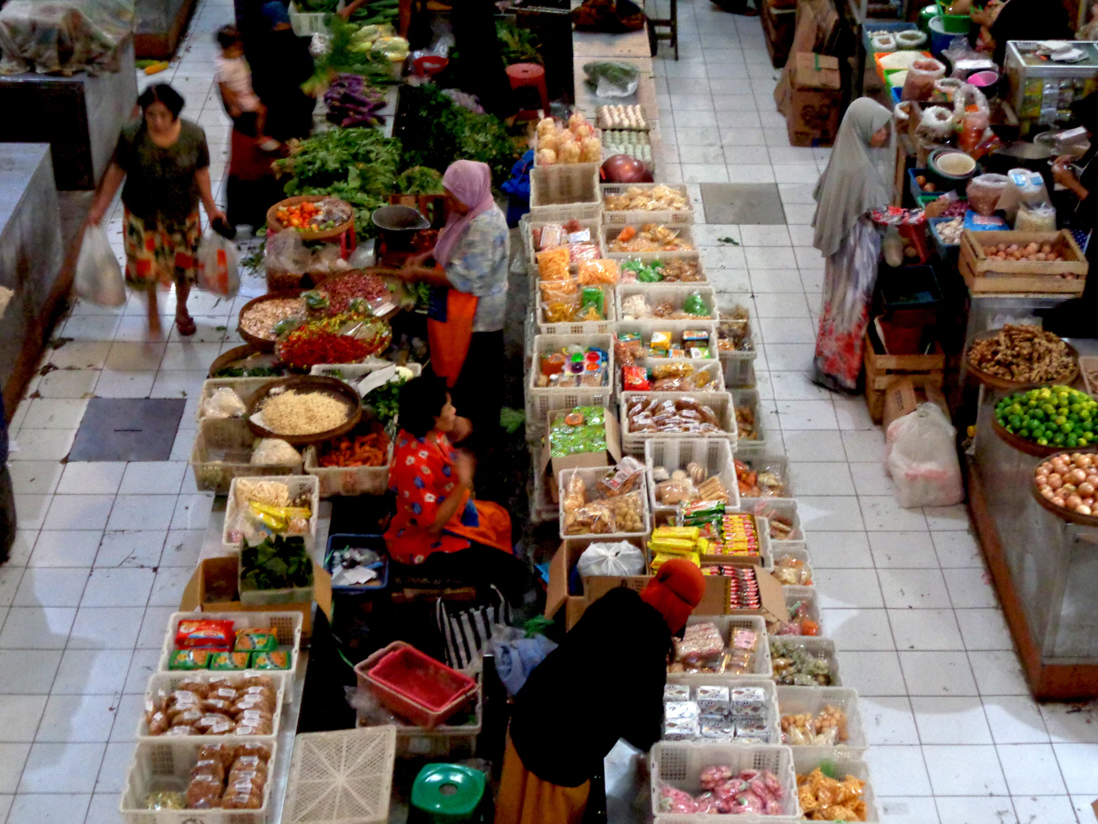 Pemandangan dari atas pasar tradisional Indonesia dengan lapak sayur dan pembeli